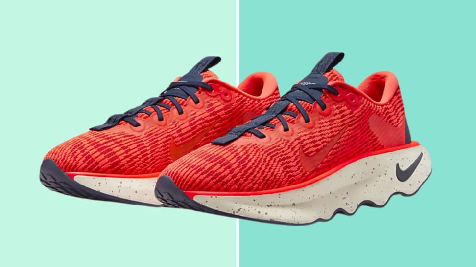 Red pair of Nike Motiva sneakers on a green background