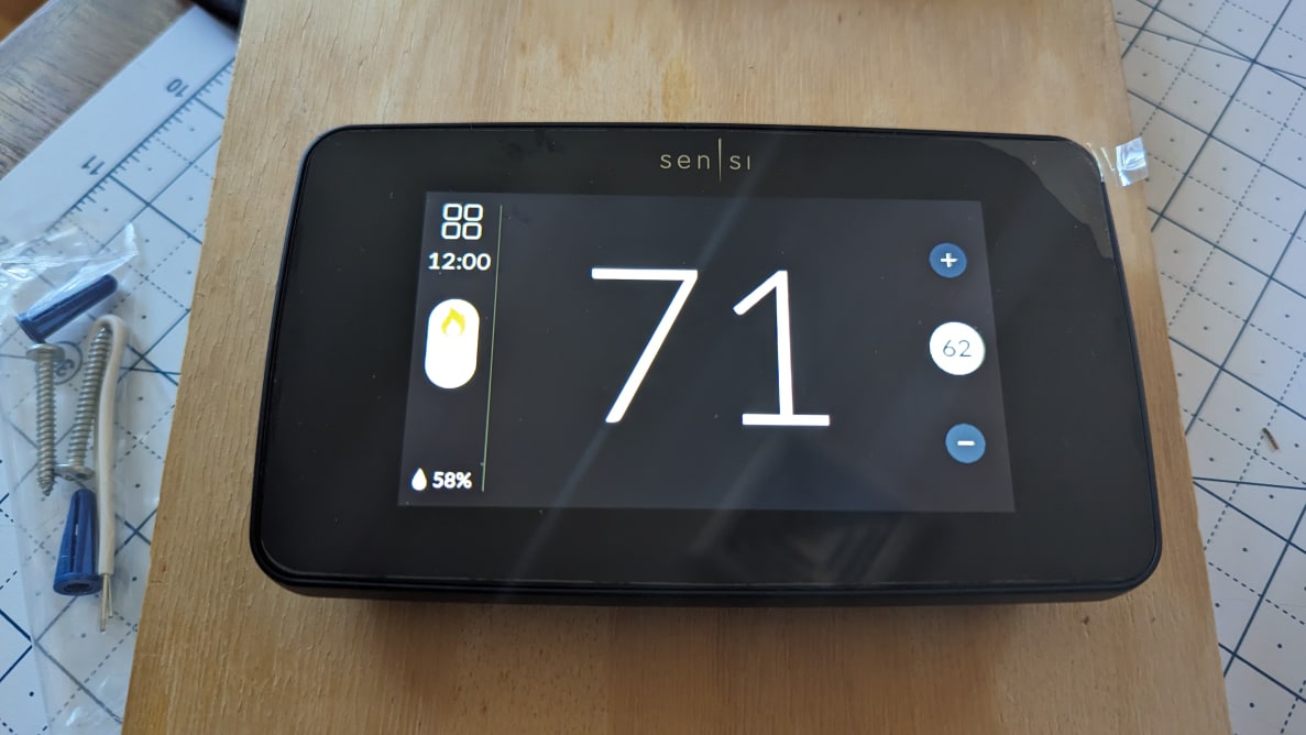 The black Sensi Smart Thermostat is shown mounted to a wood board.