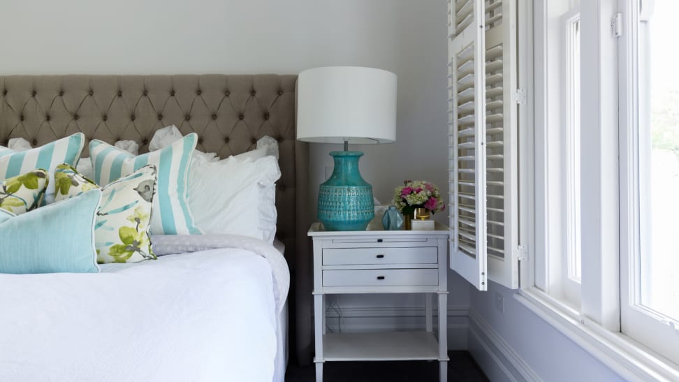 A bedroom with lavender walls and aqua accessories