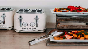 Fruits on a stainless-steel tray and white toasters, on wooden counter
