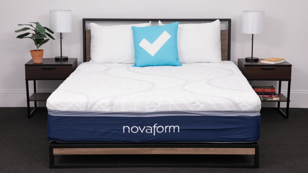 A Novaform foam mattress on a bed frame surrounded by end tables and lamps.