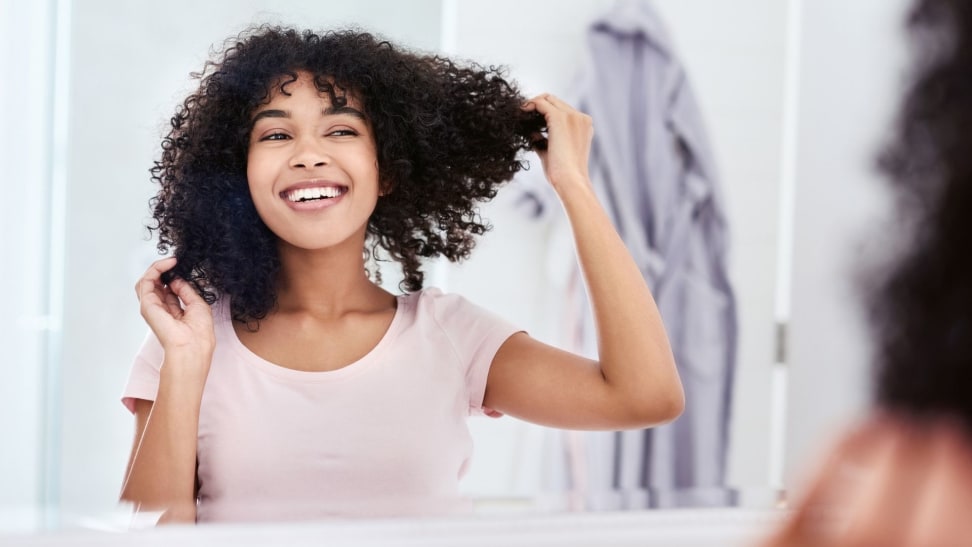 Woman with a bright white smile looking in bathroom mirror