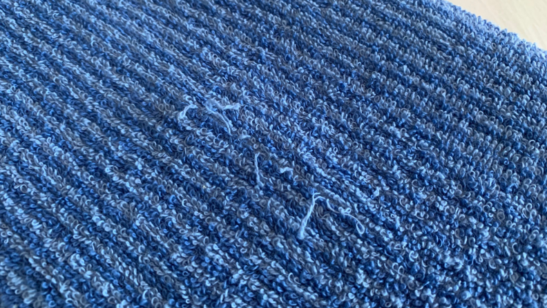 Close-up of blue towel fraying on the cotton towel material