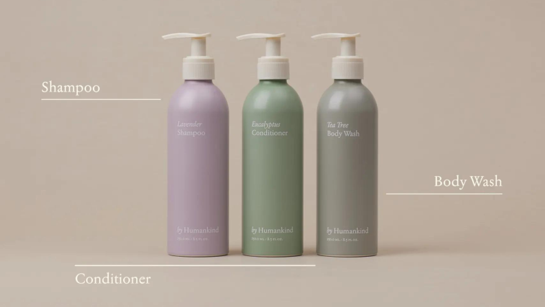 Three bottles containing shampoo in a purple bottle, conditioner in a teal bottle, and body wash in a beige bottle.