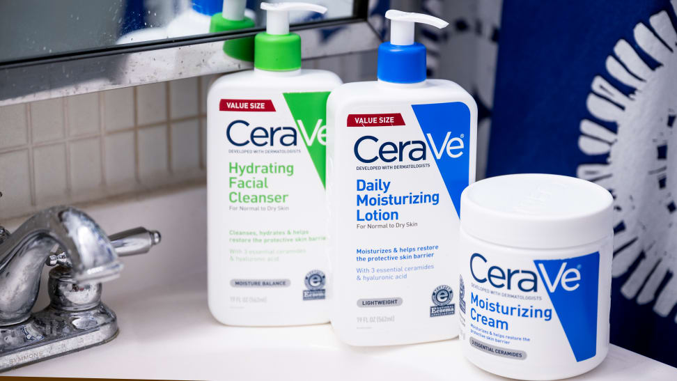 A Cerave cleanser and two moisturizers sit on a bathroom sink.