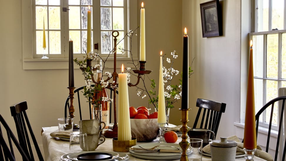 A variety of tall candles on a dining room table