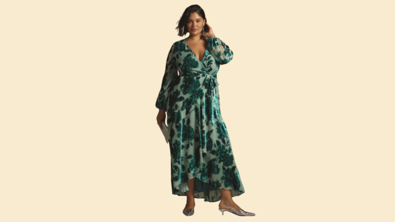 A model wearing a green dress with a floral velvet motif.