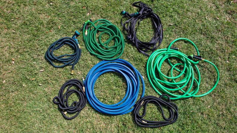 Several garden hoses laid out on the grass