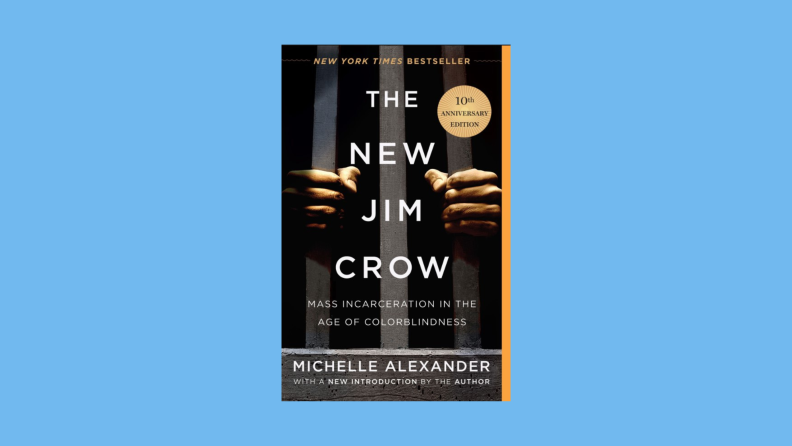 The book cover to "The New Jim Crow," by Michelle Alexander features two hands gripping prison bars.