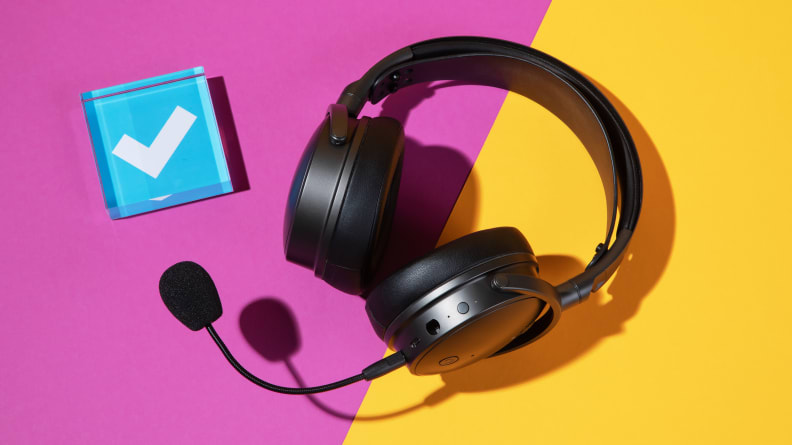 A heavy black gaming headset on a purple and yellow background with a blue checkmark next to it