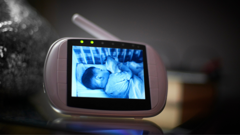 Sleeping baby in crib on screen on baby monitor.