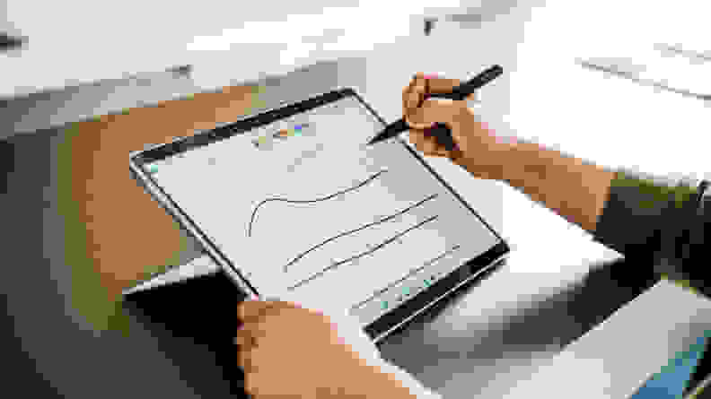 The Pro 8 in tablet mode, with someone drawing on it using Microsoft's stylus.
