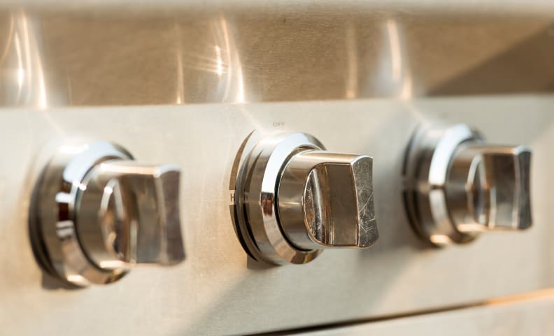 Close-up of stainless steel knobs on a grill