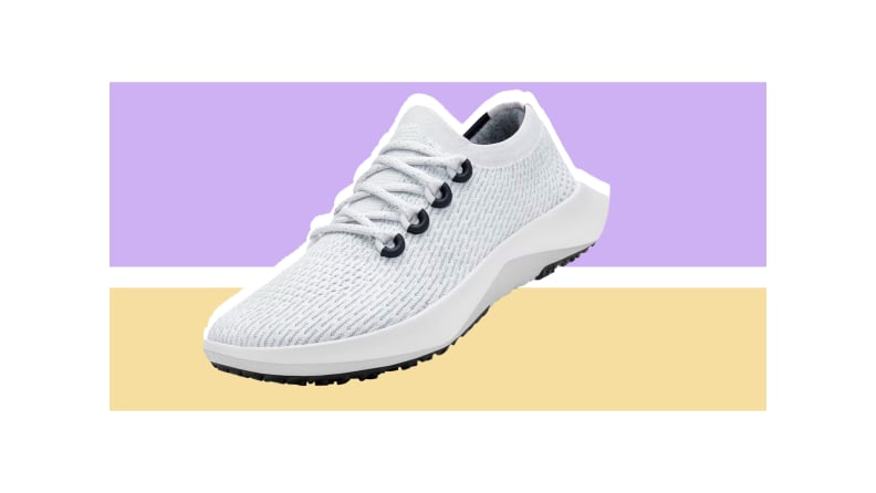 A white running shoe set against a purple and light gold background.