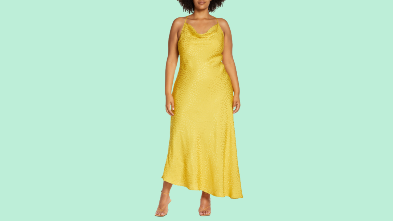 一个女人穿着一件下摆不对称的黄色吊带裙。
