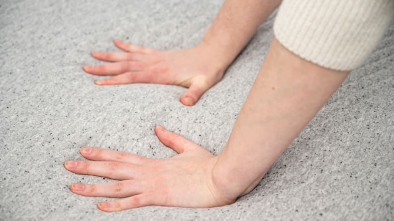hands press into the surface of the Casper mattress