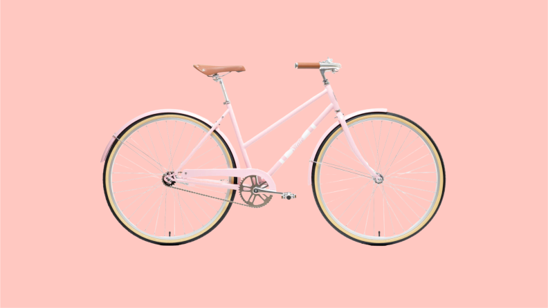A classic looking bicycle in pink featuring mustache handlebars, leatherette saddle with steel rails and retro styled metal pedals.