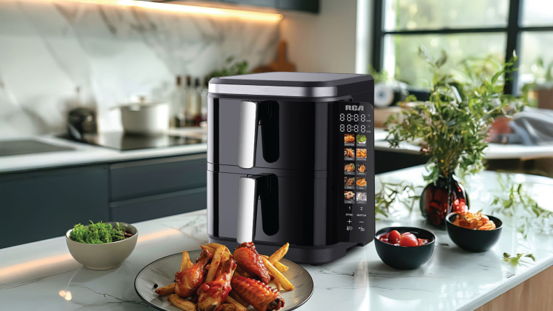 RCA black air fryer on counter with cooked food.
