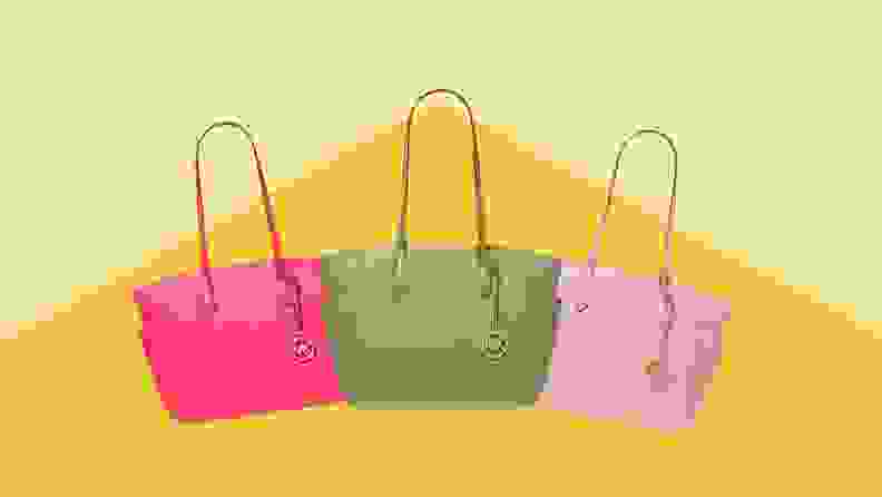 Three Michael Kors purses - hot pink, mint green, and rose pink - in front of a yellow-gold background.