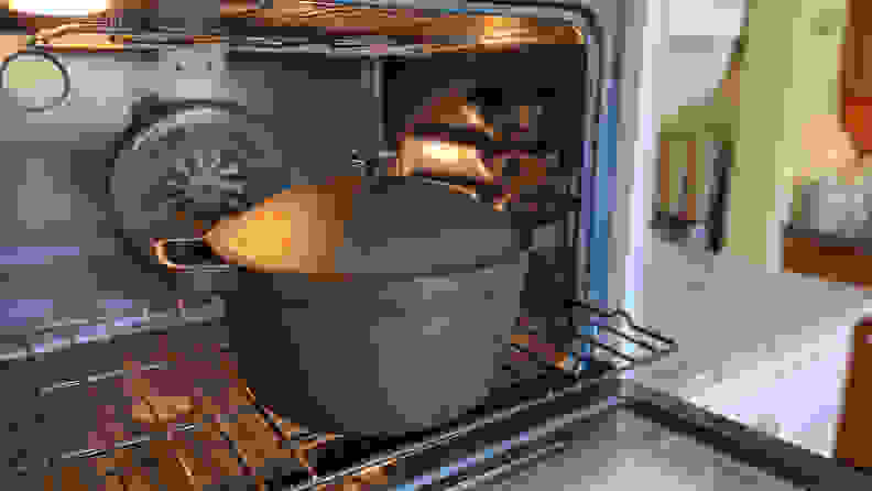 在厨房的烤箱内，下架上有一个完美的锅（黑色）。