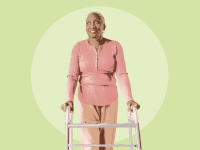 An older woman standing and leaning on a walker.