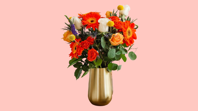 A bouquet of BloomsyBox flowers in a vase on a pink background.