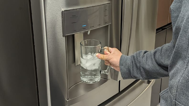 A close-up of the through-the-door dispenser. Our Lab Manager, Jonathan Chan is holding up a glass to its paddle, dispensing some ice.