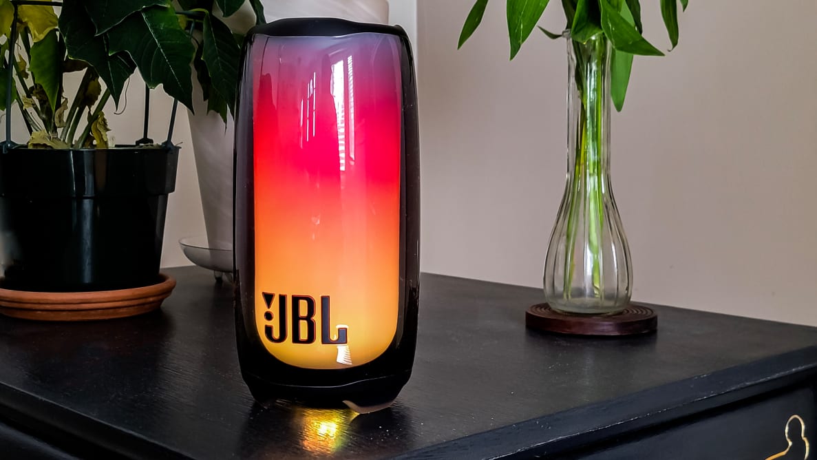 The JBL Pulse 5 on a side table with plants in the background