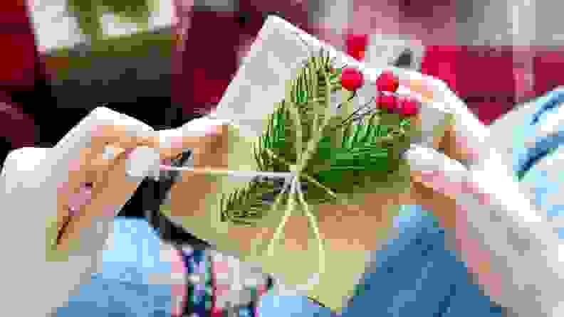 Woman holding gift wrapped in kraft paper