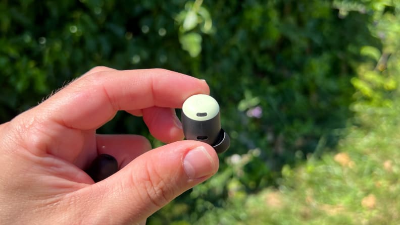 A mint green Pixel Bud Pro held in the fingers.