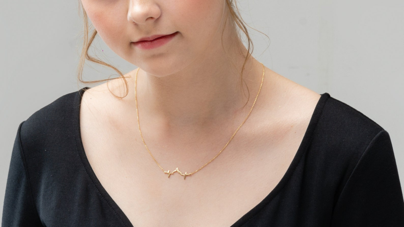 Woman wearing a gold Disney heartbeat necklace