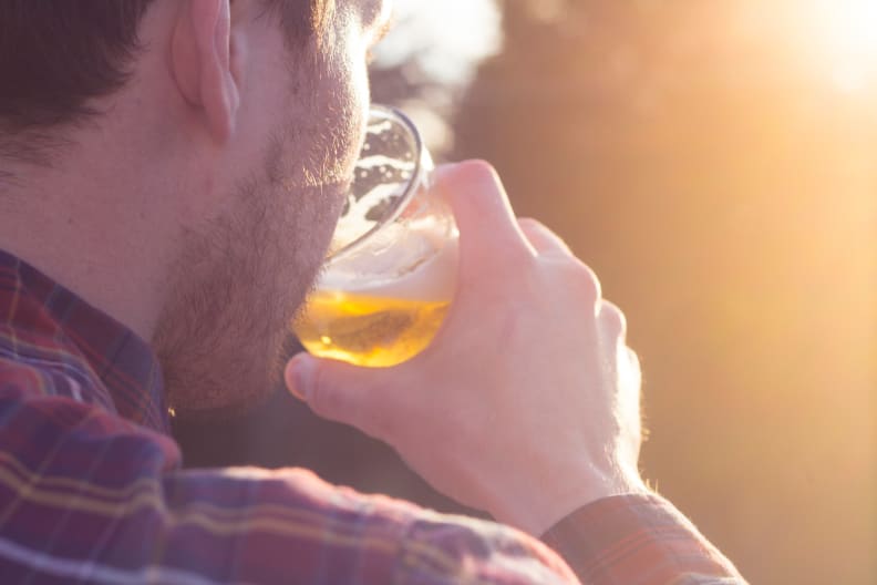 A man drinking a beer that features a Hop Theory sachet