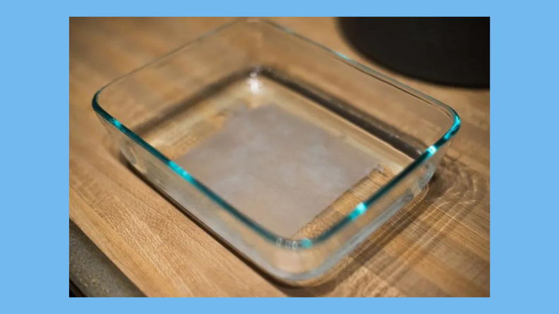 A sheet of toilet paper sits in a glass baking dish