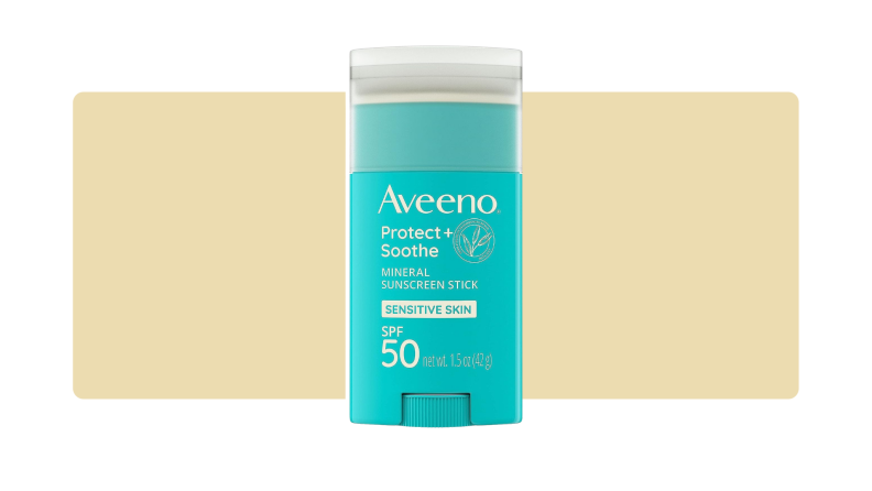 Aveeno sunscreen stick in front of a yellow background.