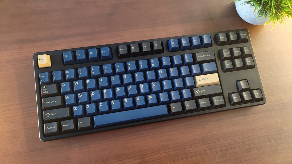 A keyboard sitting on top of a brown wooden surface