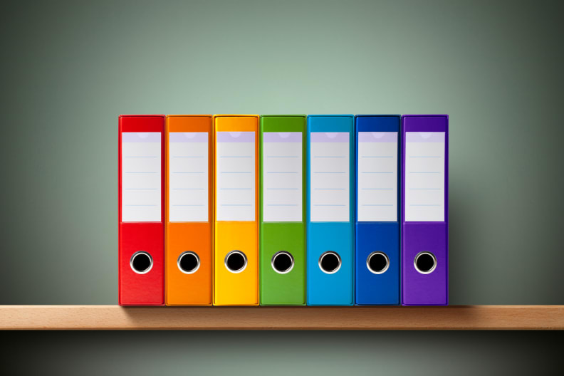Seven ring binders on the shelf.