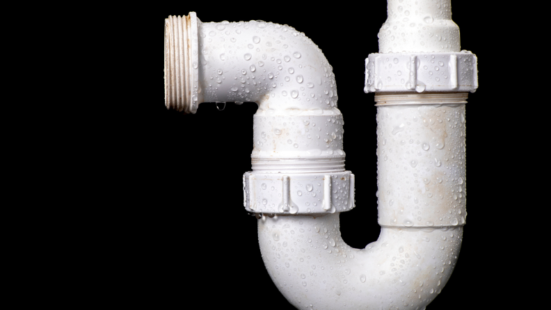 A hydraulic wet siphon for a wash basin against a black background.