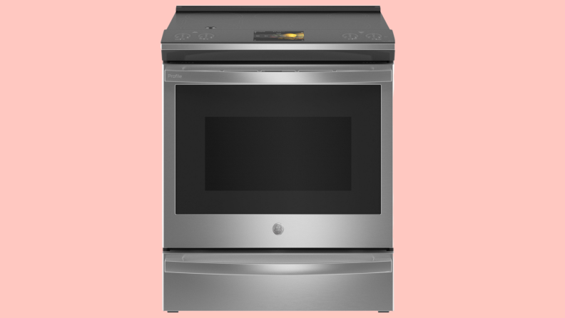 Close up of a stainless steel oven against a pink background.