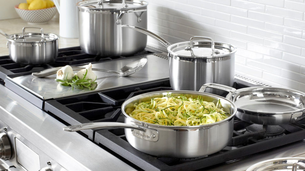 A Cuisinart cookware set is in use on a stovetop.