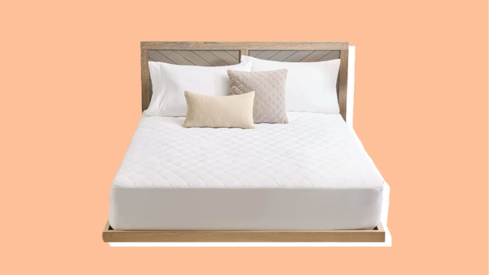 A white bed with pillows inside a wooden bed frame.