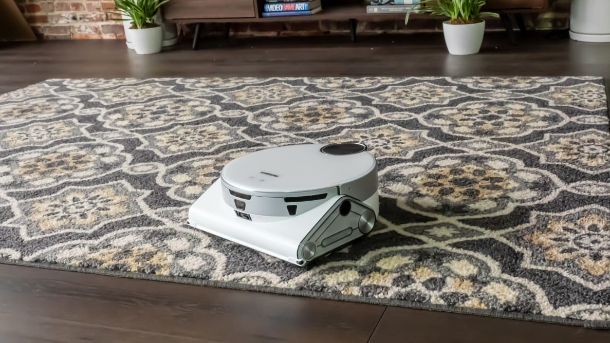 The a white robot vacuum sits on carpet