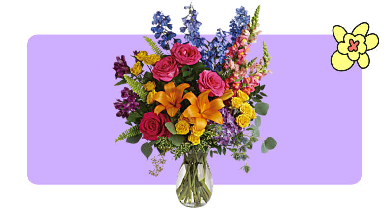 A large, colorful flower arrangement inside of a small glass vase from Teleflora.