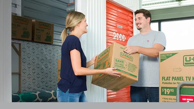 Couple storing boxed items inside a self-storage unit