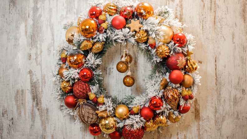 Christmas wreath with shiny ornaments and fake snow covered garland