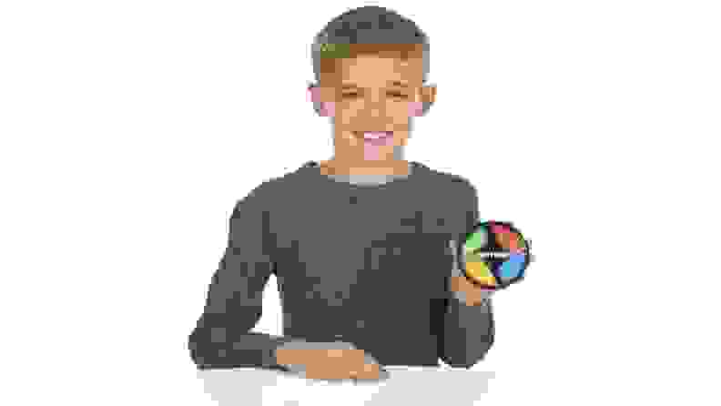 A boy holding a small Simon toy