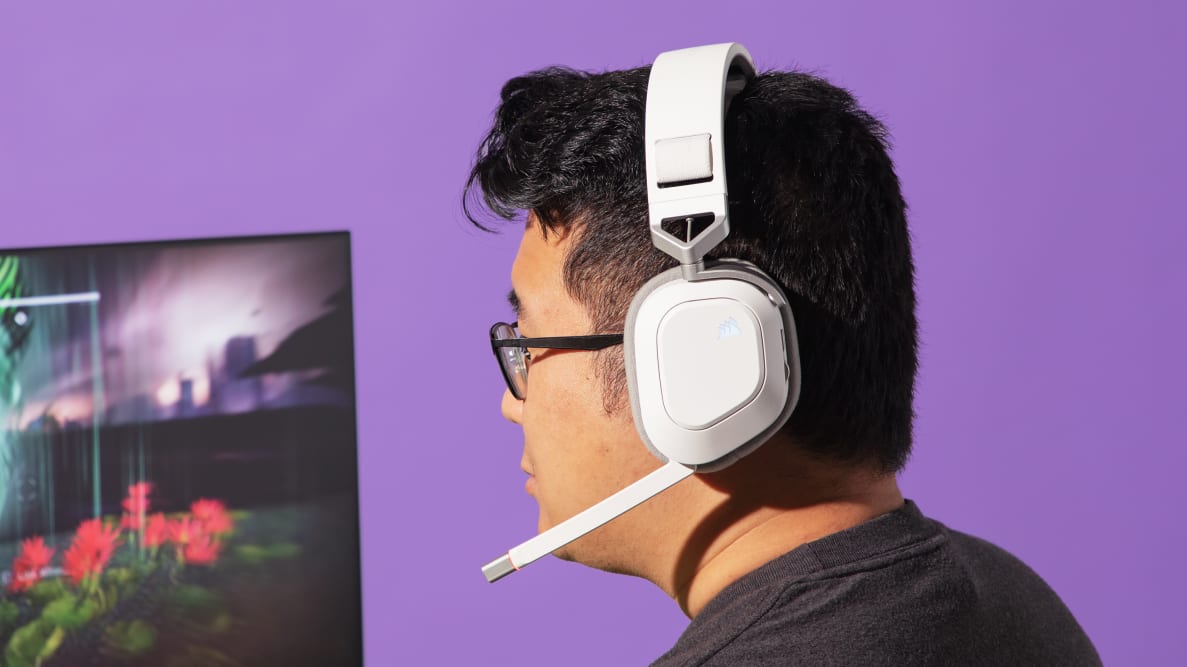 The Corsair HS80 Max, a white gaming headset, being worn with the boom mic out