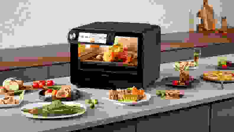 Tineco smart oven on kitchen counter surrounded by cooked food