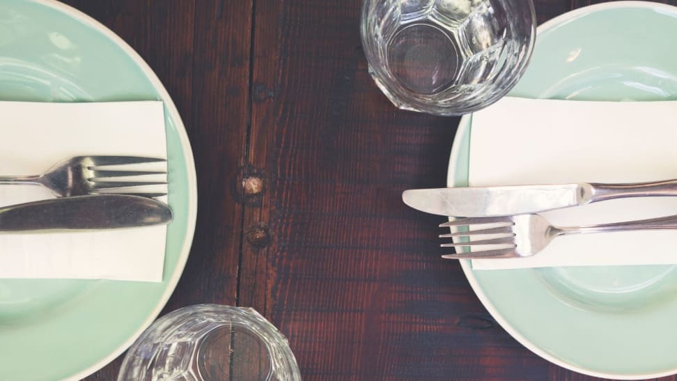 Dinner place setting for two diners on a wood table.