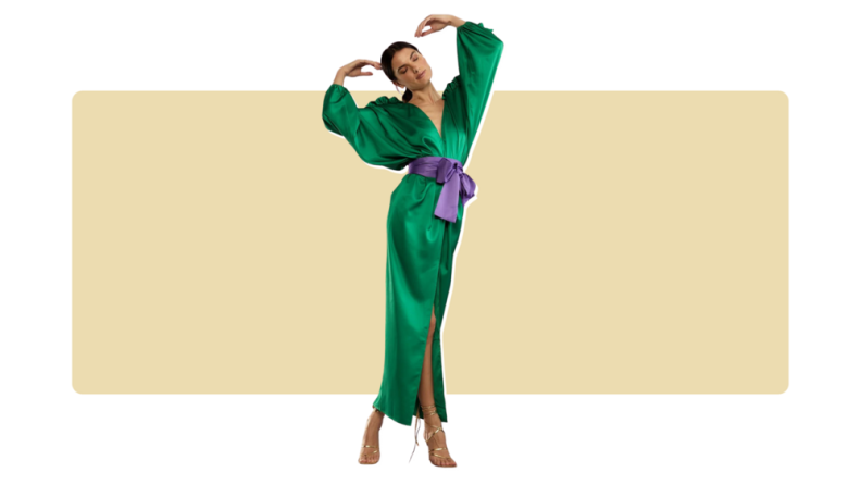 A flowing satin green dress with a purple sash.