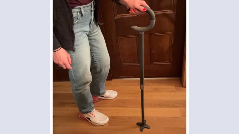 Person standing next to the CVS Health Comfort Grip Cane while firmly grasping the handle.